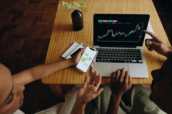 Two people collaborating over a financial chart